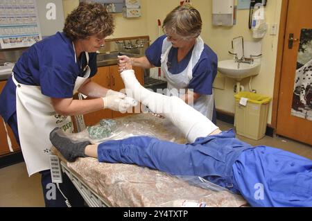 GREYMOUTH, NOUVELLE-ZÉLANDE, 19 mars 2011 : des infirmières appliquent un plâtre sur la jambe cassée d'un garçon à Greymouth, Nouvelle-Zélande, 19 mars 2011, Océanie Banque D'Images