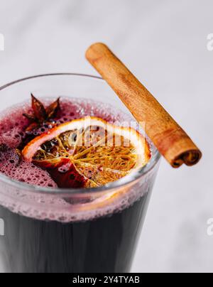 Gros plan d'un verre de vin chaud à la vapeur garni d'un bâton de cannelle et d'anis étoilé Banque D'Images