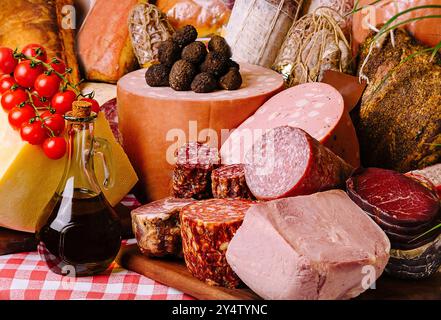 Sélection de fromages fins, de viandes et de pain élégamment agencés sur une nappe à carreaux classique Banque D'Images