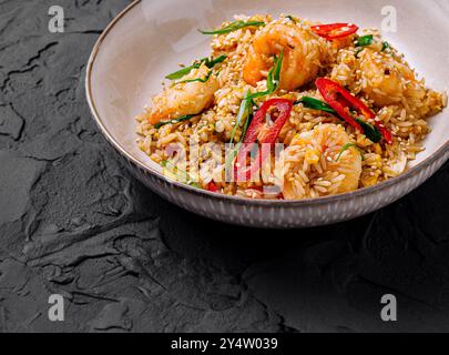 Riz frit servi dans une assiette avec crevettes, piments et oignons verts Banque D'Images