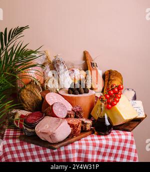 Sélection de fromages fins, de viandes et de pain élégamment agencés sur une nappe à carreaux classique Banque D'Images