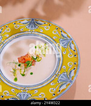 Soupe gourmande servie dans une assiette décorative avec placage artistique sur fond pêche Banque D'Images