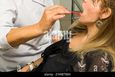 Une femme européenne dans une clinique dentaire visitant un patient pour un traitement ou une correction orthodontique. Traitement dentaire, médecine orthodontique pour les enfants an Banque D'Images