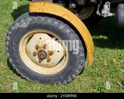 Gros plan d'une roue d'un vieux tracteur sur l'herbe Banque D'Images