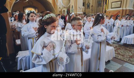 Lida, Biélorussie - 15 juin 2021 : enfants tenant des bougies lors de leur première cérémonie de sainte communion dans une église Banque D'Images