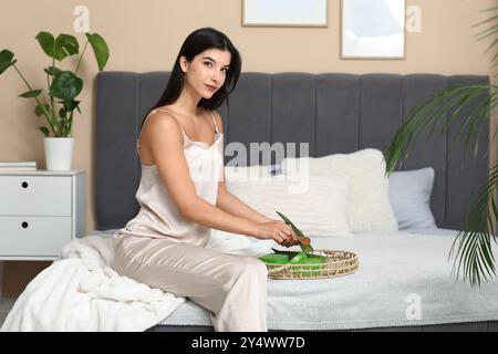 Belle jeune femme faisant du gel d'aloe vera à la maison Banque D'Images