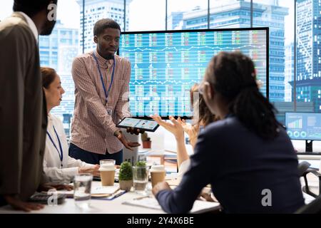 Les parties prenantes qui commencent une bagarre pendant la réunion de la société dans la salle de conseil, les investisseurs furieux en colère se crient dessus. Deux personnes causant une scène devant l'équipe des employés, argumentation. Banque D'Images