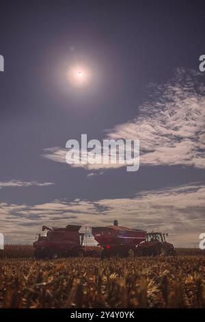 Éclipse lunaire partielle au-dessus de certains équipements agricoles International Harvester dans un champ de maïs partiellement récolté. Récolte 2024 Banque D'Images