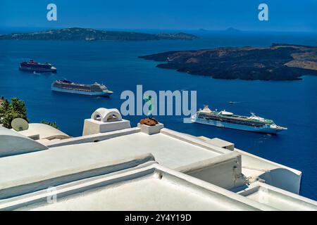 Vue tôt le matin de la baie de Fira sur l'île de Santorin, Grèce. Toits blancs, statue d'hippocampe, Nea Kameni, et les bateaux de croisière de luxe dans la baie Banque D'Images