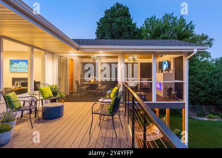 Terrasse au niveau supérieur de la maison donnant sur le porche avec moustiquaire trois saisons avec cheminée et télévision Banque D'Images