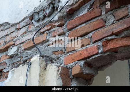 La texture du vieux mur de briques est battue par les intempéries Banque D'Images