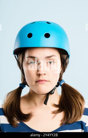 Cyclisme, casque et portrait de femme en studio avec confiance, voyage ou style esthétique rétro sur maquette. Vélo, sécurité et visage sérieux de fille avec Banque D'Images