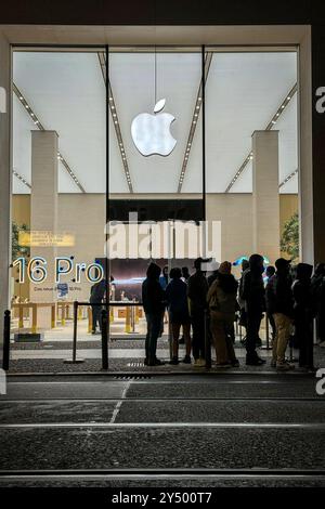 Berlin, Allemagne. 20 septembre 2024. Les passants se tiennent devant le magasin Apple à Mitte. C'est là que commencent les ventes des nouveaux modèles iPhone 16 et iWatch 10 d'Apple. Apple se concentre sur de meilleurs appareils photo et l’intelligence artificielle dans ses nouveaux iPhones. Cependant, les utilisateurs de l'Union européenne ne connaîtront pas initialement beaucoup des nouvelles fonctions de l'IA. Crédit : Katharina Kausche/dpa/Alamy Live News Banque D'Images