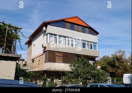 Mélange unique d'architecture moderne et traditionnelle dans une maison à flanc de colline entourée de verdure par une journée ensoleillée Banque D'Images