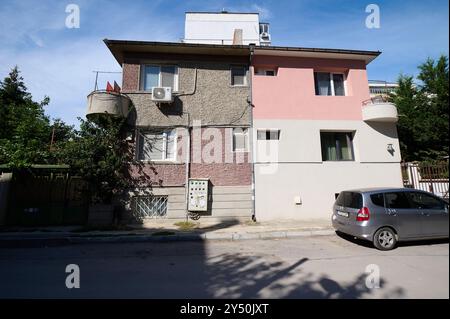 Maison moderne à architecture mixte présentant des éléments de design uniques dans un quartier résidentiel sous la lumière du soleil Banque D'Images