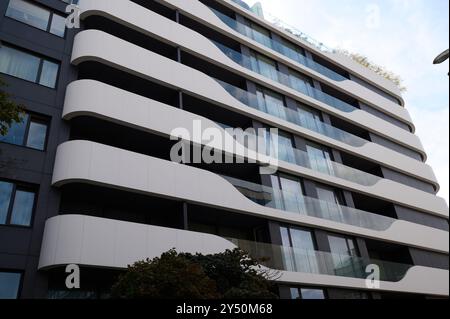 Conception architecturale moderne d'un immeuble résidentiel élégant avec balcons courbes dans un cadre urbain Banque D'Images