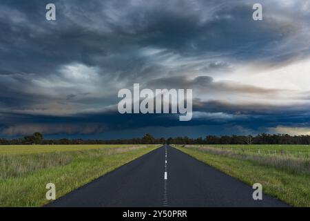 Vue au niveau du sol d'un spectaculaire front de tempête approchant au-dessus d'une route de campagne à Eddington dans le centre de Victoria, Australie Banque D'Images