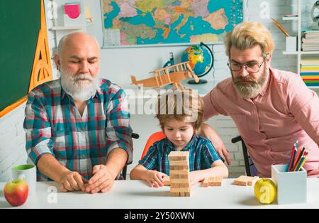 Concept de style de vie de famille de bonheur. Week-end des valeurs parentales de l'enfance. Portrait de plusieurs générations masculin. Grangfather, Père et fils jouant jenga Banque D'Images