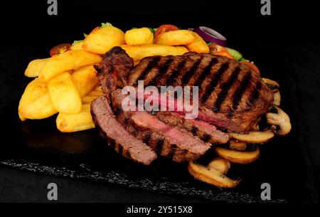 Steak de bœuf grillé avec grosses frites et salade Banque D'Images