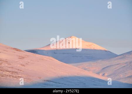 Montagnes avec des ombres de coucher de soleil sous ciel bleu sans nuages Banque D'Images