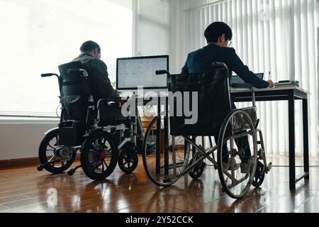 Collègues handicapés travaillant sur des ordinateurs Banque D'Images