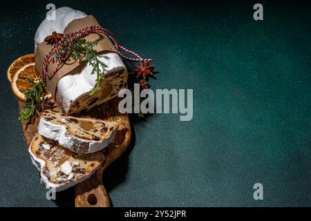 Classique de Noël Dresdner Stollencake avec fruits secs, épices, arbre de Noël et décoration sur fond de béton vert foncé Banque D'Images