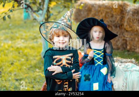 Deux enfants comme squelette ou sorcière prêt pour le truc ou le plaisir. Groupe surprise petit zombie dans Halloween déguisements manger traite, calaverita sucreries bougies. Banque D'Images