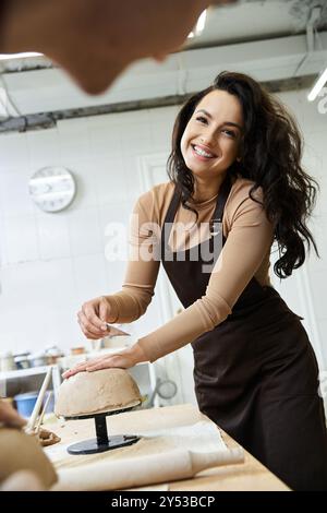 Homme attrayant positif avec les cheveux foncés faisant de la poterie. Banque D'Images