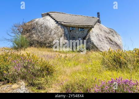 Maison Boulder ou Casa do Penedo, une maison construite entre d'énormes rochers au sommet d'une montagne à Fafe, Portugal. Banque D'Images