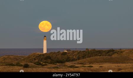 Moisson supermoon se lève derrière le phare de Barns Ness, Dunbar, East Lothian, Écosse, Royaume-Uni Banque D'Images