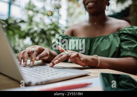 Gros plan moyen de mains féminines manucurées tapant sur le clavier Banque D'Images