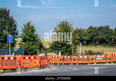 travaux routiers pour réparer, entretenir ou améliorer un revêtement routier marqué par des barrières rouges et blanches pour prévenir les accidents. Banque D'Images