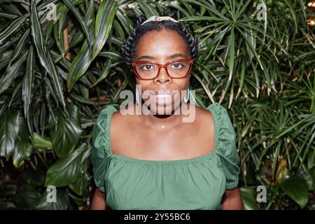 Plan à angle élevé de la magnifique femme afro-américaine souriant légèrement et regardant directement la caméra Banque D'Images