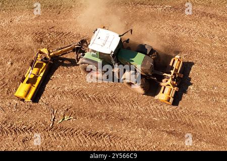 Themenfoto : Landwirtschaft. Ein Landwirt faehrt mit seinem Traktor ueber einn abgeerntetes Maisfeld und verjunegt den Boden mit der Schaelfraese,Schlepper, Traktorspuren. *** Photo thématique Agriculture Un agriculteur conduit son tracteur sur un champ de maïs récolté et désherbe le sol avec la houe rotative, tracteur, tracteurs chenilles Banque D'Images