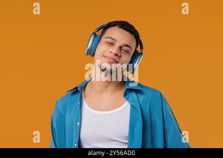 Homme de race mixte positif écoutant de la musique, profitant de la danse avec des écouteurs modernes Banque D'Images