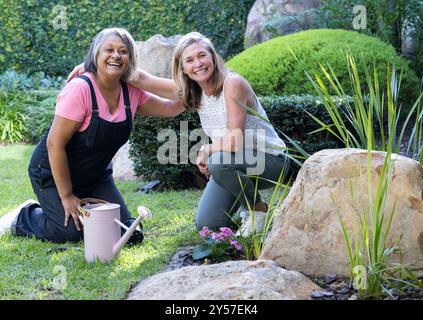 Jardiner ensemble, deux amies féminines multiraciales seniors souriant et profitant de l'activité de plein air Banque D'Images