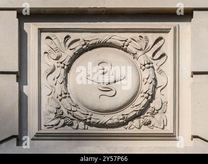 Londres, Royaume-Uni. Royal College of Nursing, 20 Cavendish Square détail sur la façade - serpent et la «lampe de l'apprentissage» Banque D'Images