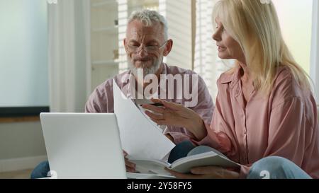 Sérieux senior senior retraité vieux couple caucasien femme femme mari homme documents de travail documents financiers utilisent un ordinateur portable pc. Femme homme parler Banque D'Images