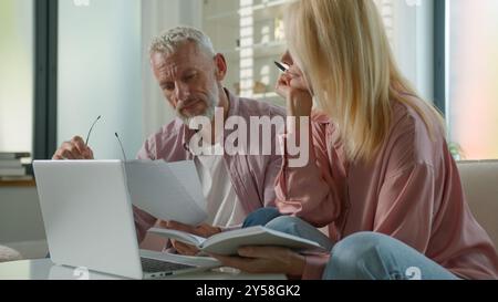 Famille pensive aînée aînée couple caucasien mature des années 60 femme homme mal de tête utilisez un pc portable. Frustré grands-parents femmes hommes paiement e-business Banque D'Images