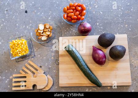 À la maison, préparer des ingrédients frais de salade, y compris le concombre, l'avocat et les tomates cerises Banque D'Images