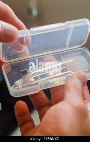 main masculine tenant arc en plastique avec deux buses d'irrigation. Photo de haute qualité Banque D'Images