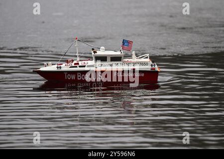 Un modèle de bateau rouge et blanc navigue sur un lac en face de la lisière de glace Banque D'Images