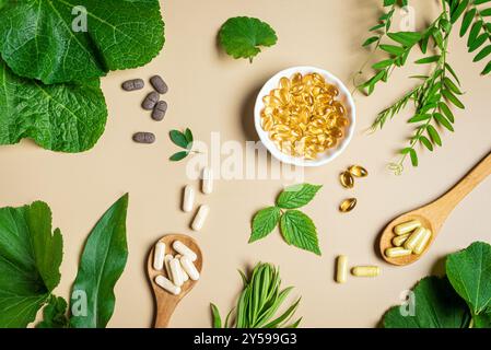 Compléments à base de plantes. Vitamines organiques. Homéopathie et phytothérapie alternative. Capsules et pilules végétaliennes, feuilles de plantes vertes sur fond beige Banque D'Images