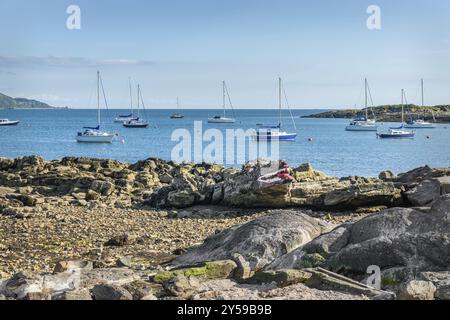 Crocodile Rock sur la plage de Millport sur Cumbrae en Écosse avec Eilean Island dans la baie de Millport Banque D'Images