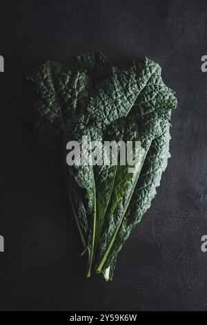 Cavolo nero noir curly kale légume sur noir Banque D'Images