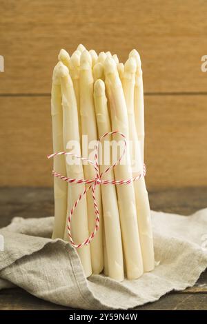 Bouquet d'asperges blanches sur une table en bois avec du linge de lin Banque D'Images
