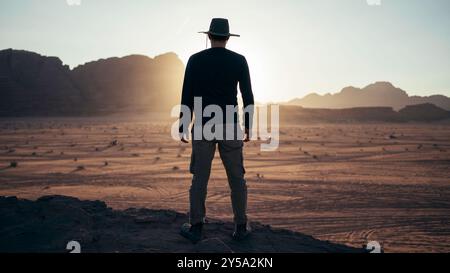 Touriste regardant le désert de Wadi Rum lors d'un beau coucher de soleil. Banque D'Images