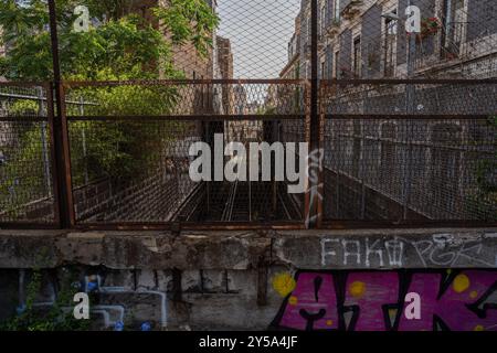 Catane, Italie - 20 mai 2024 : chemin de fer caché : graffitis et verdure contrastent avec l'atmosphère industrielle des voies ferrées de Catane. Banque D'Images