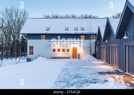 Côté de la maison nordique moderniste montrant la cour et les garages séparés par trois sommets de toit Banque D'Images