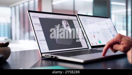 Ingénieur masculin développant des pièces mécaniques à l'aide d'un logiciel de CAO 3D sur ordinateur portable au bureau de l'usine Banque D'Images